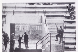 Pie de foto: Prisionero arrodillado frente a militar en el Estadio Nacional, 1973. En Cozzi, Adolfo. Estadio Nacional. Santiago
