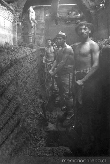 Trabajadores al interior de un cachucho, oficina salitrera Tránsito, hacia 1900