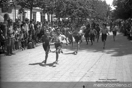 Niños corren durante competencia por celebración del Día del Roto Chileno en Plaza Yungay, 1944