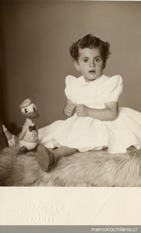 Niñita de vestido vaporoso, chalas y calcetines blancos, junto al personaje Pato Donald, ca. 1950