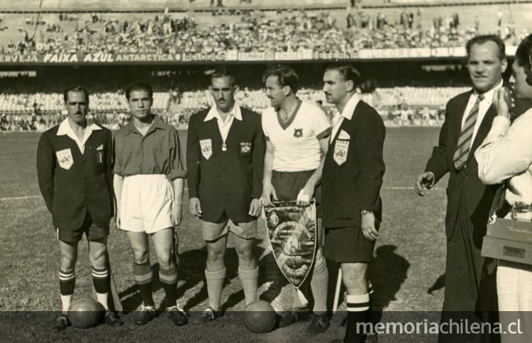 capitanes de España, Agustín Gaínza, y de Chile, Sergio Livingstone, junto al trío referil encabezado por el árbitro brasileño Alberto Malcher, antes del partido por el Mundial de España, en el