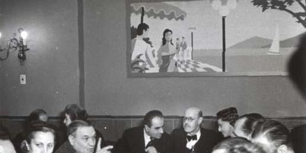 Guillermo Feliú Cruz con grupo de personas en un almuerzo, hacia 1960